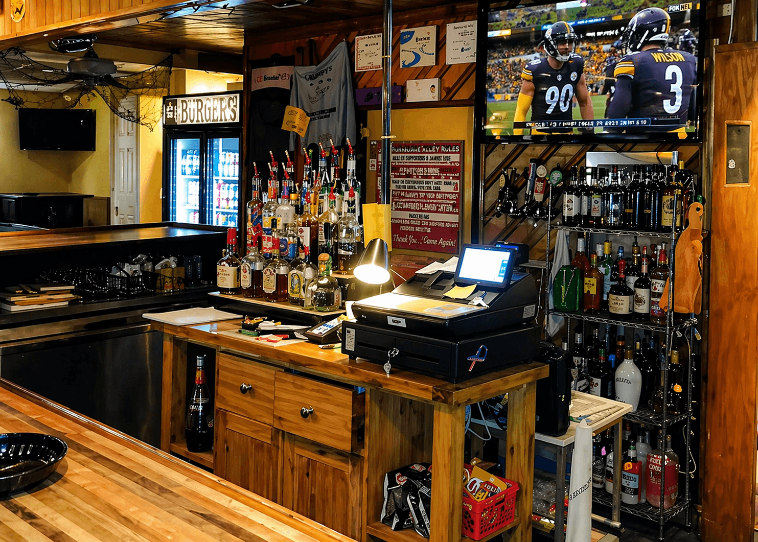 BoRocks bar area with bottles, register, TV, and wood counter